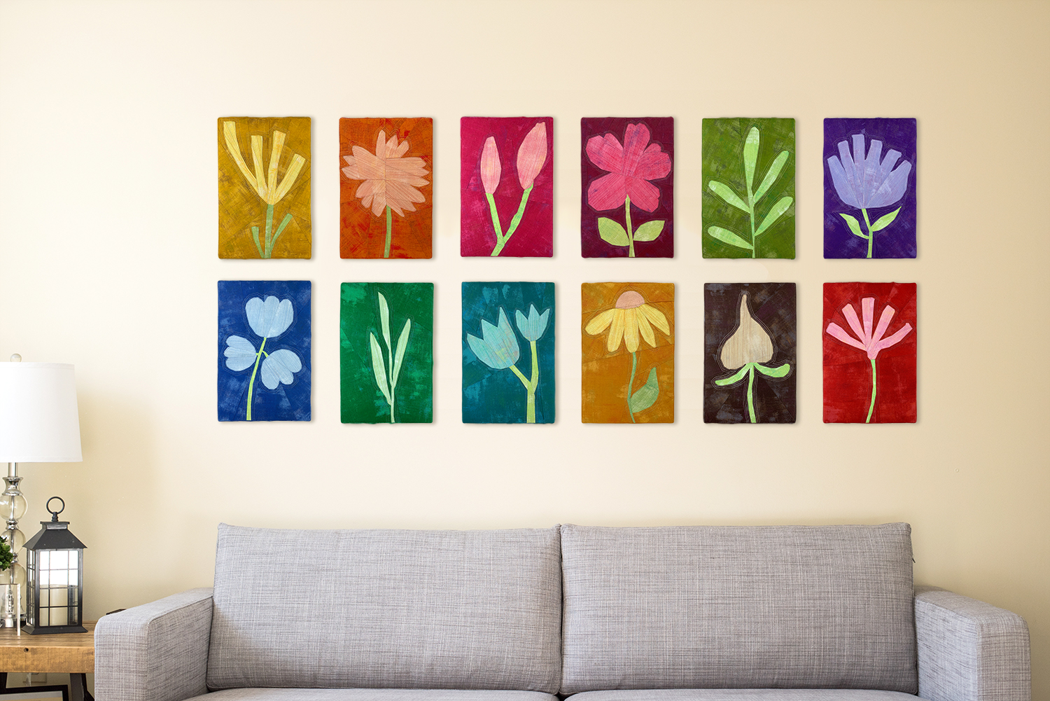 12 colorful floral quilted art pieces stretched over frames.