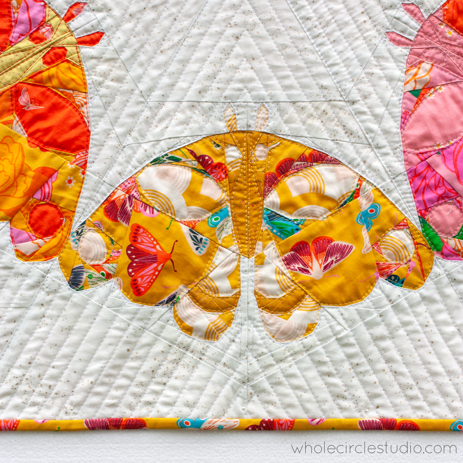 detail of a modern art quilt with a moth design motif