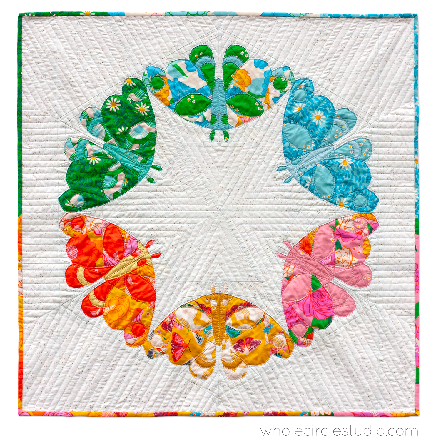 a modern art quilt with 6 colorful moths in a circle