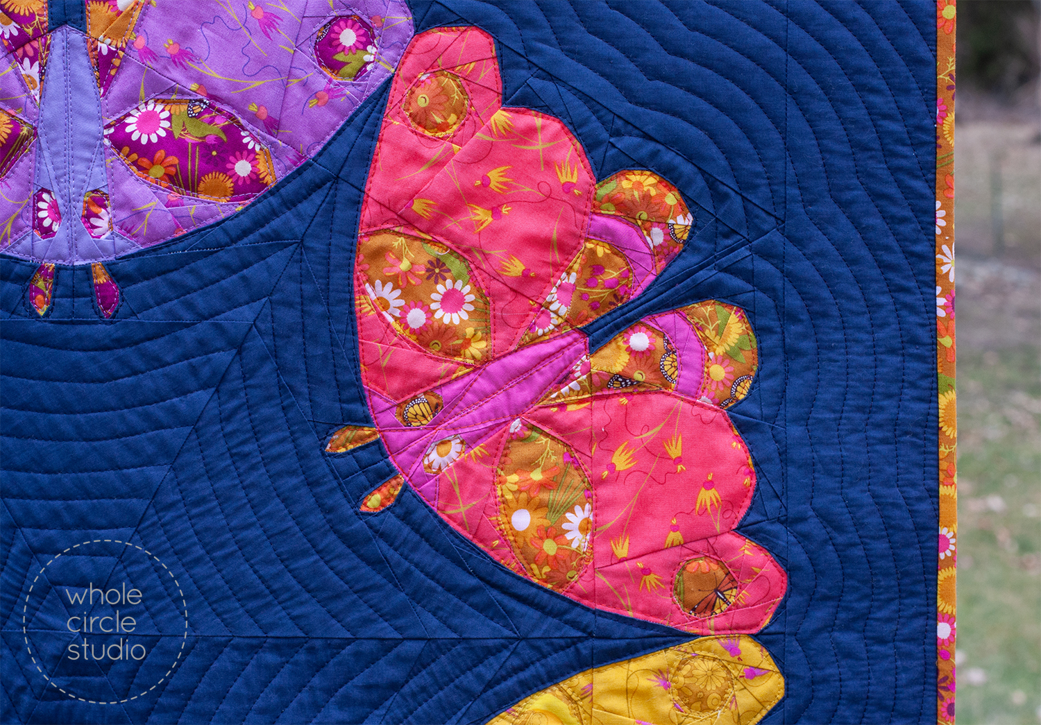 detail of a modern art quilt with 6 colorful moths in a circle